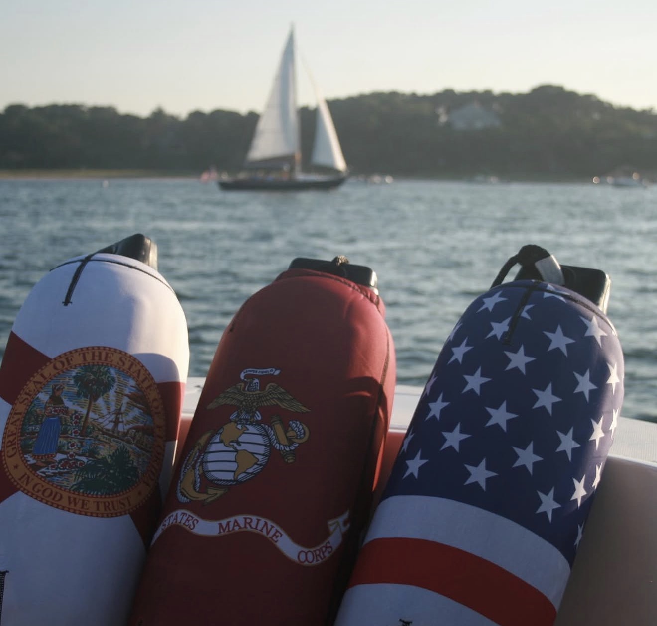 Florida state flag, US Marine Corps, and American flag custom fender covers on water
